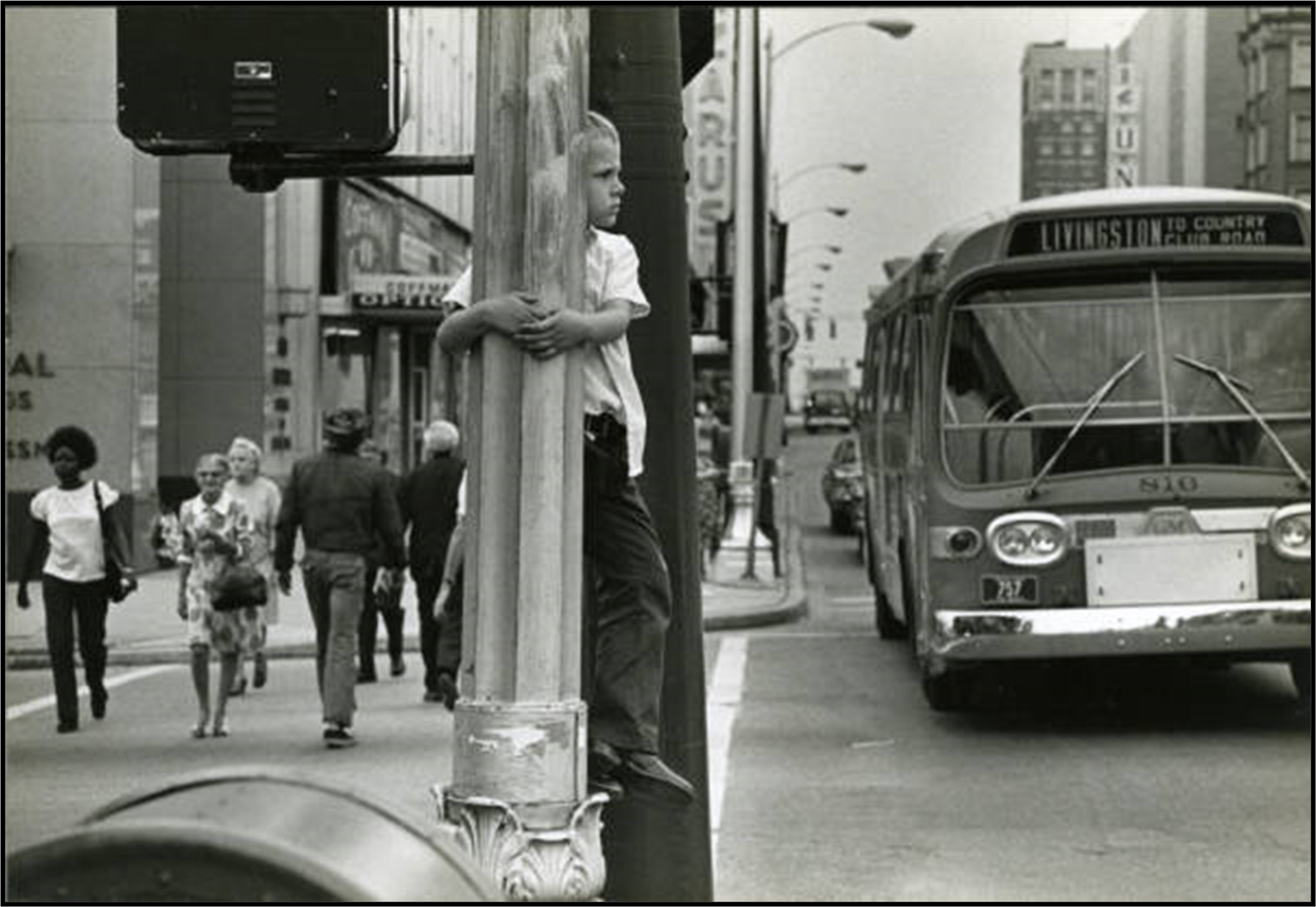 vintage image of boy holding lamppost with COTA bus in background