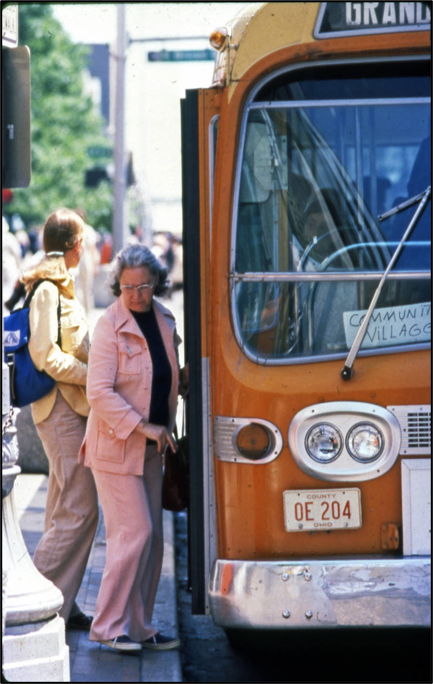 a woman boarding a vintage COTA bus